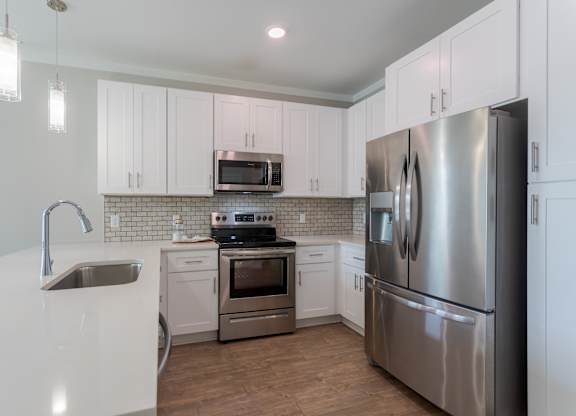 A modern kitchen with stainless steel appliances and white cabinets.