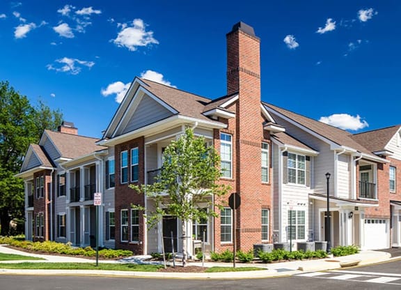 a street scene of a row of townhomes with a blue sky in the background at Canopy at Ginter Park Apartments, Richmond, VA, 23227