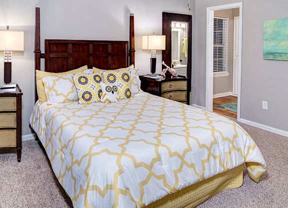 A bedroom with a bed, nightstand, and lamp at Austin Chase Apartments, Macon, 31210