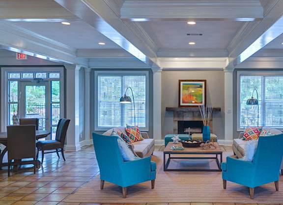 A living room with a fireplace and two chairs at Austin Chase Apartments, Georgia