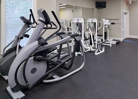 A gym with treadmills, elliptical machines, and other exercise equipment at Austin Chase Apartments, Macon, Georgia