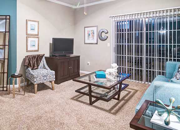 A living room with a couch, chair, and television at Austin Chase Apartments, Macon, GA