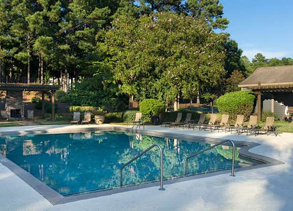 A large outdoor swimming pool surrounded by trees at Austin Chase Apartments, Macon, Georgia
