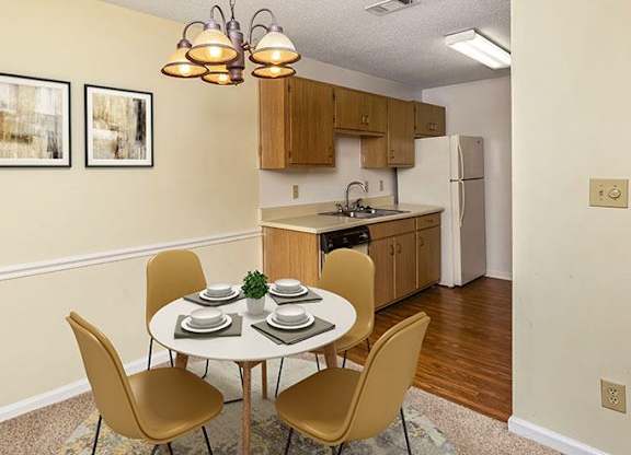 A kitchen with a table and chairs in the foreground.