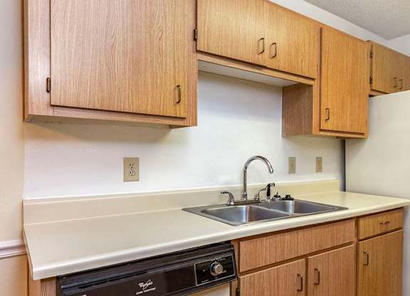 A kitchen with wooden cabinets and a white refrigerator.