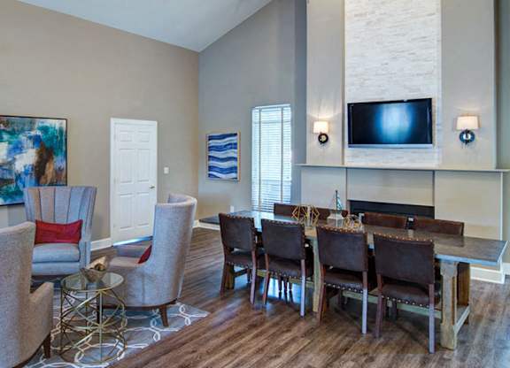 A living room with a grey sofa, a white armchair, and a wooden coffee table at Huntington Chase Apartments, Warner Robins, 31088