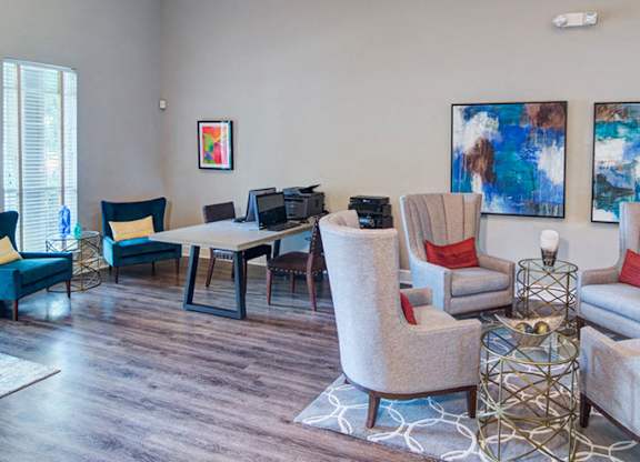 A living room with a blue chair and a glass table at Huntington Chase Apartments, Warner Robins, GA 31088