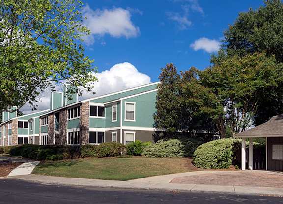 A green and white building with a gazebo-like structure in front.