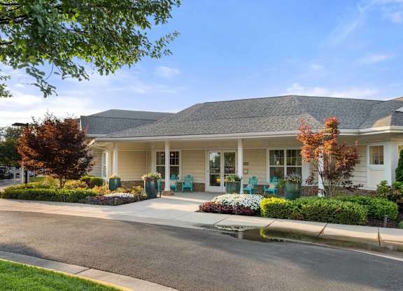 Clubhouse entrance with covered porch and landscaping at Colony at Centerpointe Apartments, Virginia