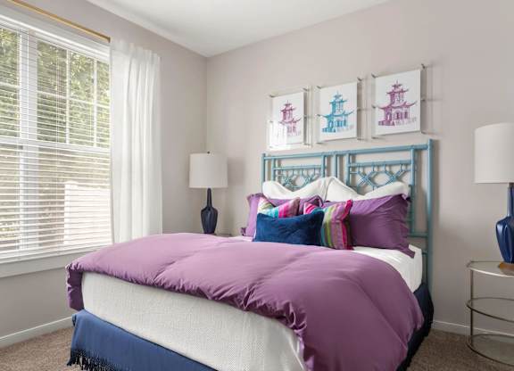 Bedroom with colorful bedding and pagoda artwork at Colony at Centerpointe Apartments, Midlothian, VA