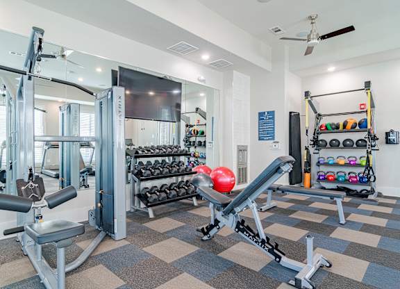 A gym with a variety of equipment including a leg press machine.