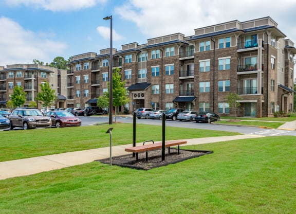 an apartment building with a park bench in front of it at Residence at Riverwatch, Augusta, Georgia