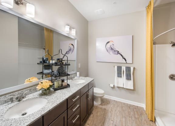 a bathroom with two sinks and a mirror and a toilet at Residence at Riverwatch, Augusta