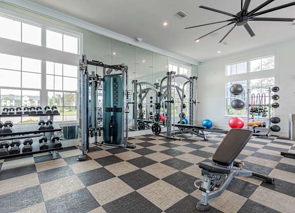 A spacious gym with a variety of equipment and a checkered floor.