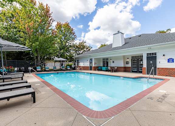 A small pool in front of a building with a blue sign.
