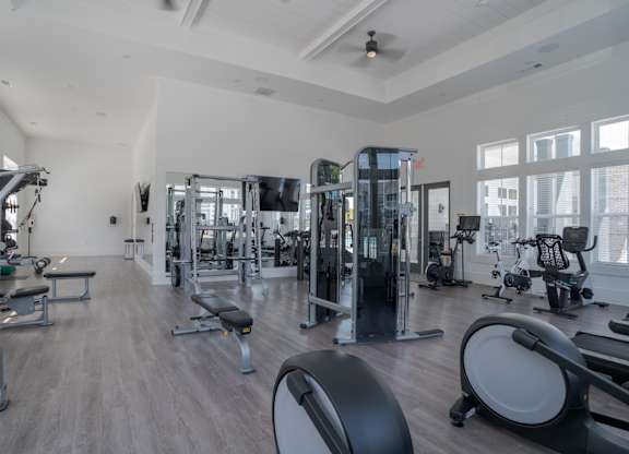 A spacious gym with a variety of equipment including treadmills, weights, and exercise machines.