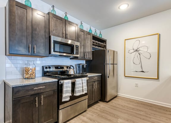 a kitchen with stainless steel appliances and wooden cabinets at Retreat at Arden Farms, Arden, NC