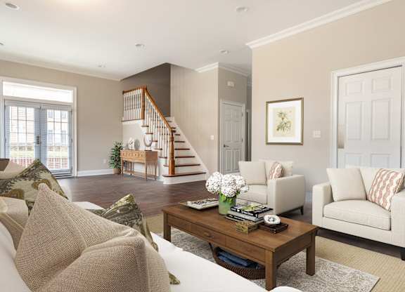 A living room with a staircase and a couch.