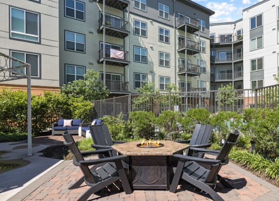 an outdoor patio with a firepit and four chairs at Rivergate, Virginia