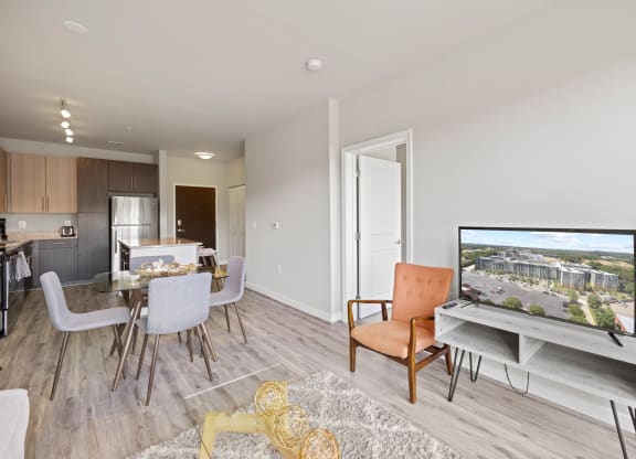 a living room with a tv and a dining room in the background at Rivergate, Woodbridge, Virginia