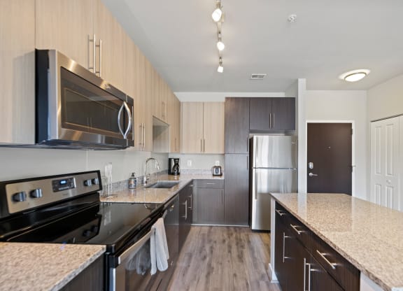 a kitchen with granite countertops and stainless steel appliances at Rivergate, Woodbridge