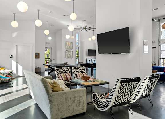 A living room with a white couch and a black and white patterned chair.