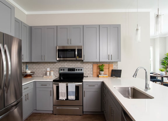 a kitchen with stainless steel appliances and white cabinets at One Riverside Apartments, Tennessee, 37403