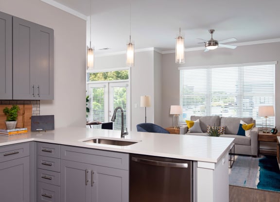 a kitchen with an island and a living room with a couch at One Riverside Apartments, Tennessee, 37403