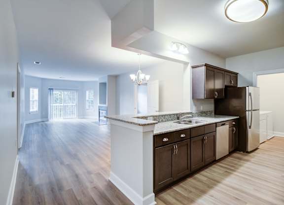 A kitchen with dark wood cabinets and a white island.