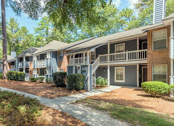 A row of houses with a tree in the foreground. at The Colony at South Park, Aiken, 28903