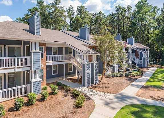 A large two-story house with a balcony and a covered patio. at The Colony at South Park, Aiken