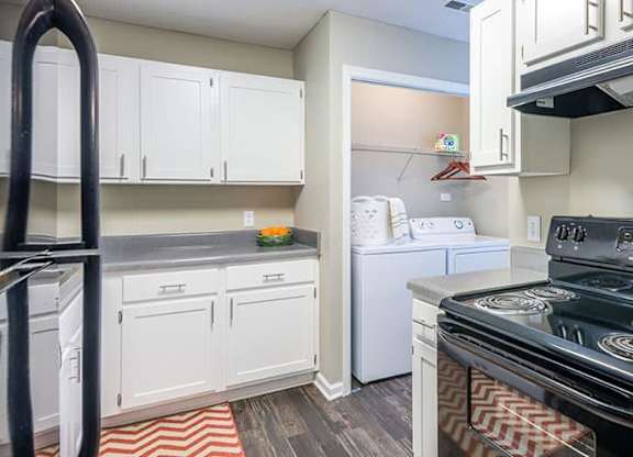 A kitchen with a black stove top oven and white cabinets. at Woodwinds, Aiken, 29803