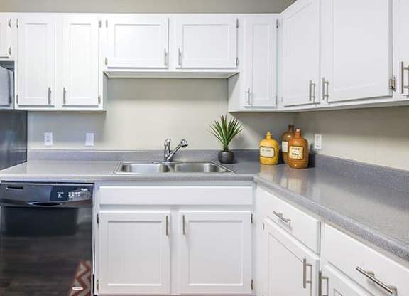 A kitchen with white cabinets and a black fridge. at Woodwinds, South Carolina