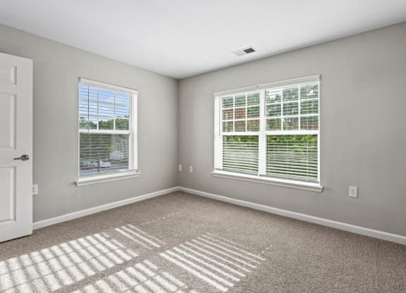 an empty room with two windows and a door at SomerHill Farms Apartments, Gainesville, 20155