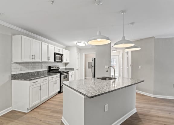 a kitchen with white cabinets and a marble counter top at SomerHill Farms Apartments, Gainesville, VA 20155