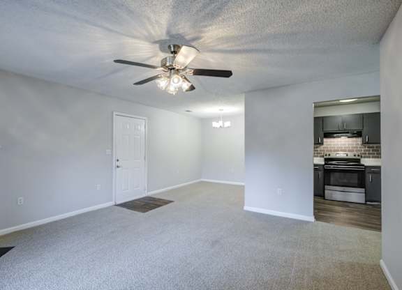 A spacious room with a ceiling fan and a fireplace at Southland Station Apartments in Warner Robins, 31088
