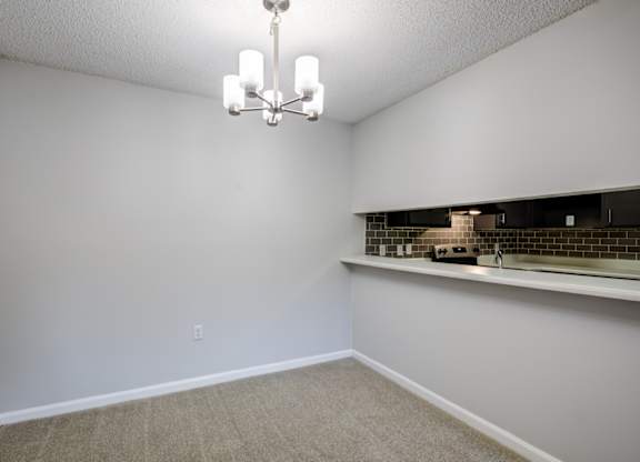 A room with a chandelier and a counter with a backsplash at Southland Station Apartments in Warner Robins, Georgia