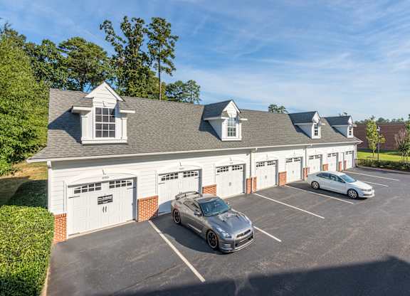 A car is parked in front of a garage.