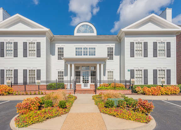 A white building with a black fence and a circular window on the top.