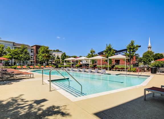 A swimming pool surrounded by a concrete floor and benches.