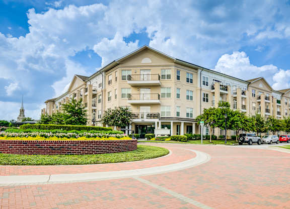 A large apartment complex with a red brick walkway in front.