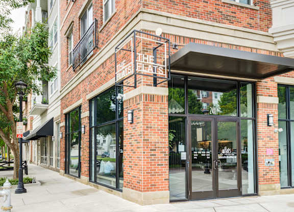The entrance to a building with a glass door and a sign that reads