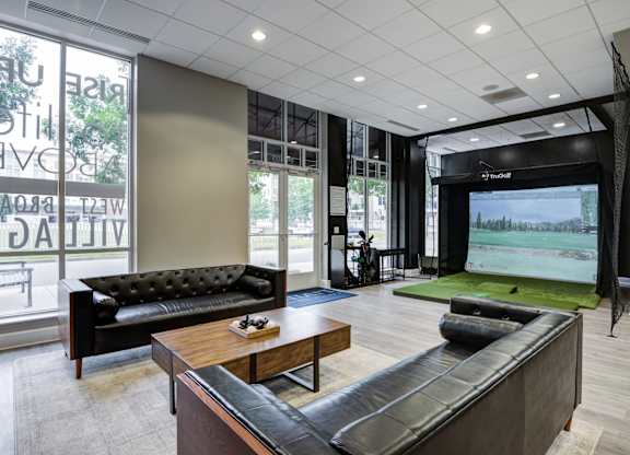 A modern living room with a black couch and a television.