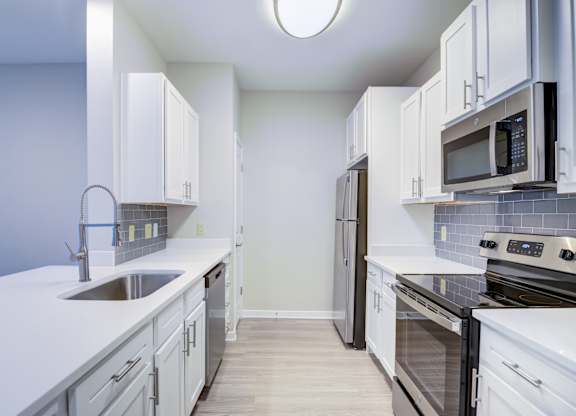 A kitchen with white cabinets and a black stove top oven.
