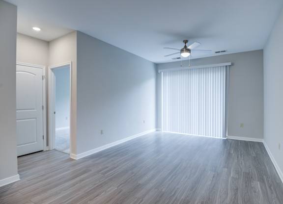 A room with a ceiling fan and lighting fixture.