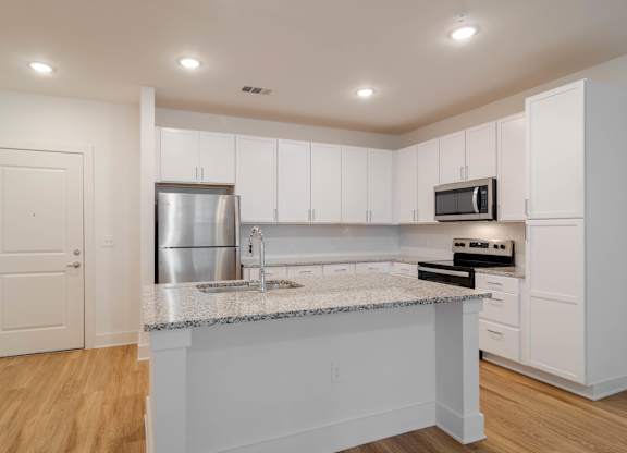 A kitchen with white cabinets and a granite countertop.