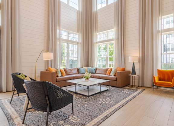 A living room with a sofa, two chairs, and a coffee table.