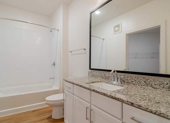 A bathroom with a marble countertop and a white toilet.