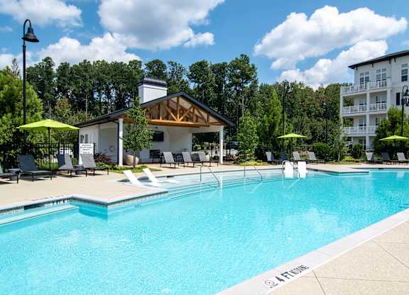 A pool with a white building behind it.