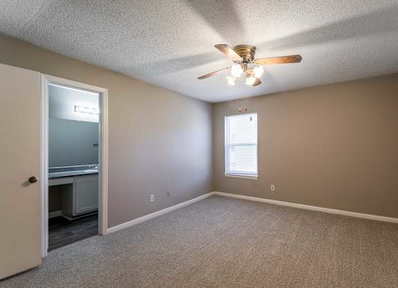 A room with a ceiling fan and a window.